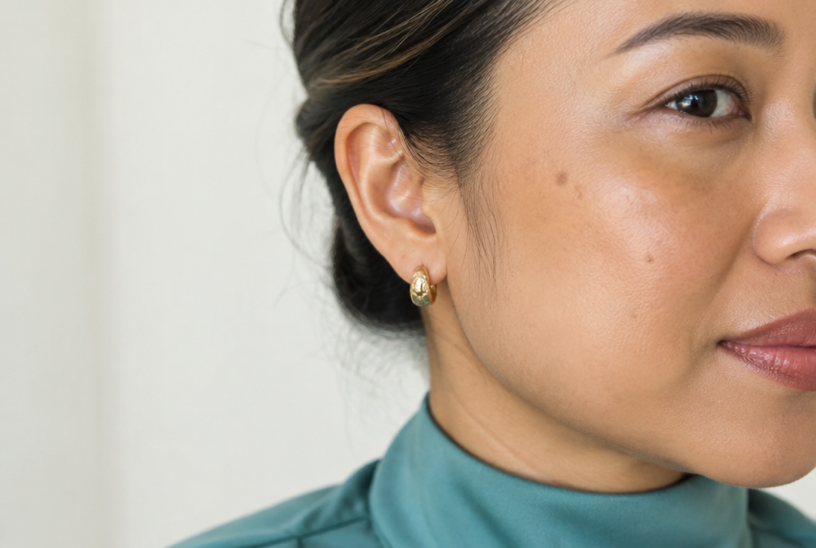 Close-up of a woman's cheek showing a few sun spots in natural light